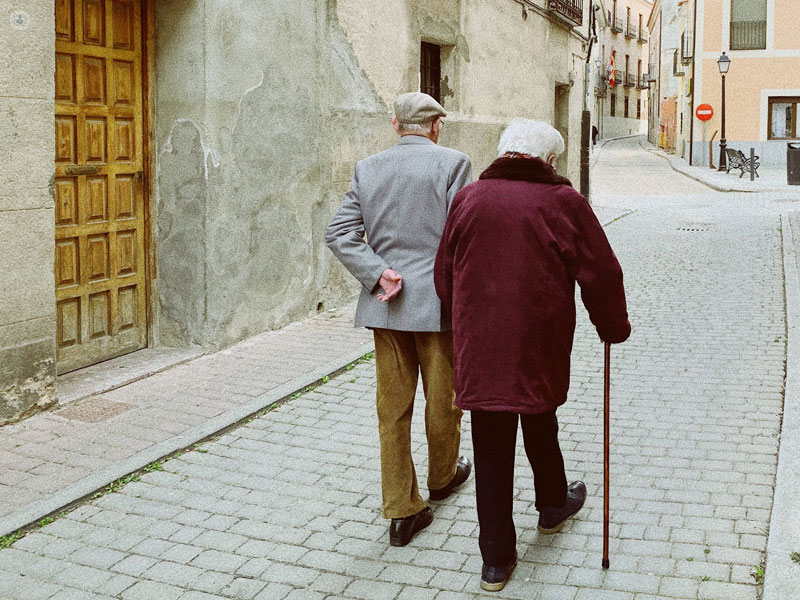 coppia di anziani che camminano con bastone