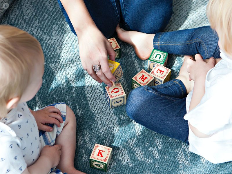 bambini che giocano con la mamma seduti sul prato