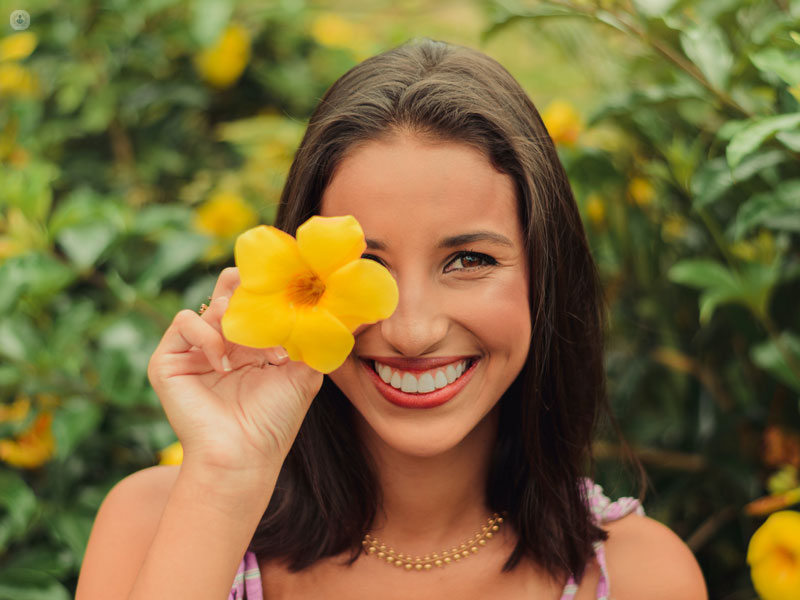 ragazza che sorride con un fiore nella mano