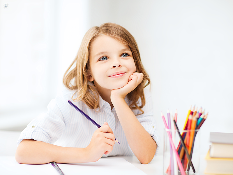 bambina che studia sorridendo