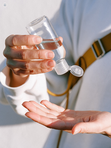 persona che utilizza un disinfettante per le mani