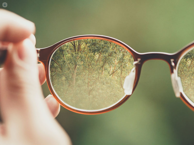 persona che afferra occhiali da vista per vedere meglio