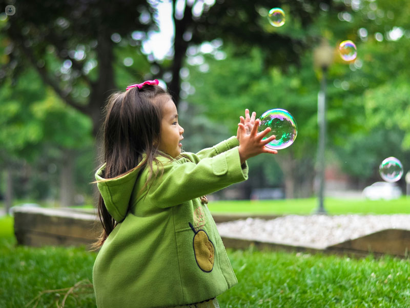 bimba che gioca con bolle di sapone