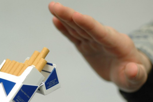 mano che ferma le sigarette per smettere di fumare