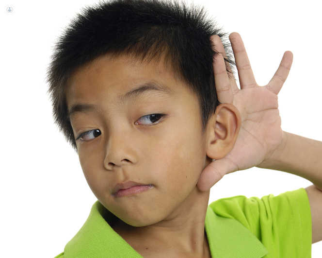 bambino con la mano all'orecchio per ascoltare meglio