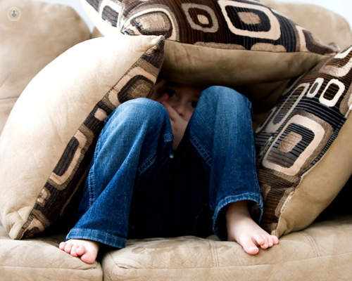bimbo si nasconde dietro ad alcuni cuscini per un inizio di depressione infantile