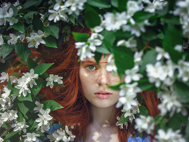 viso di una ragazza circondata da fiori