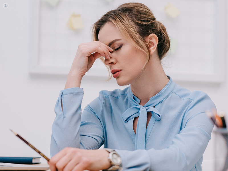 donna stressata che si tocca il viso