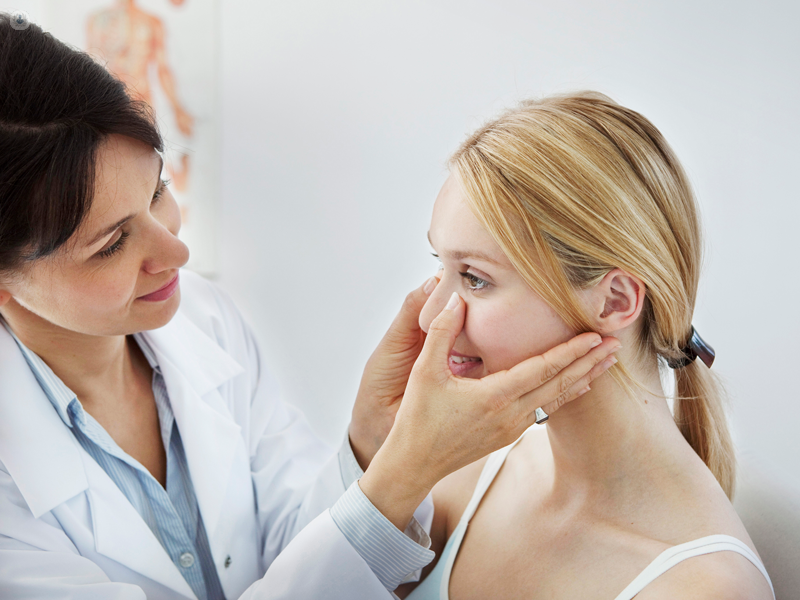 Medico che visita il naso di una ragazza
