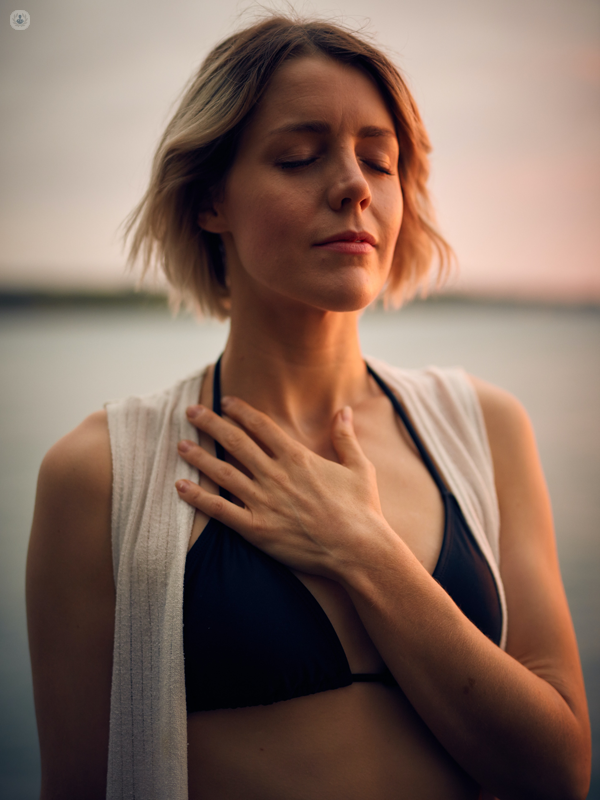 ragazza che si tocca il petto all'altezza del cuore