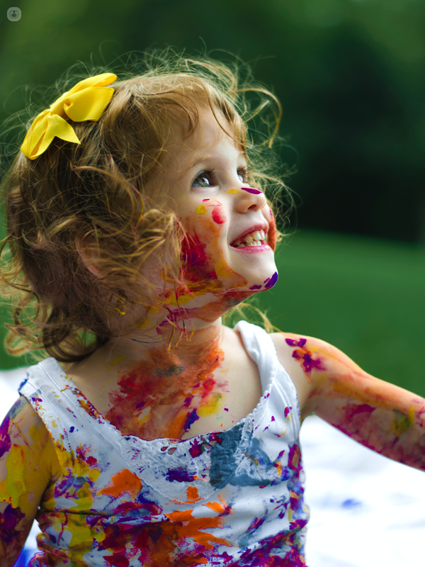 bambina che sorride con colori sul corpo