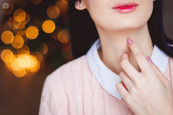 donna che si tocca il collo