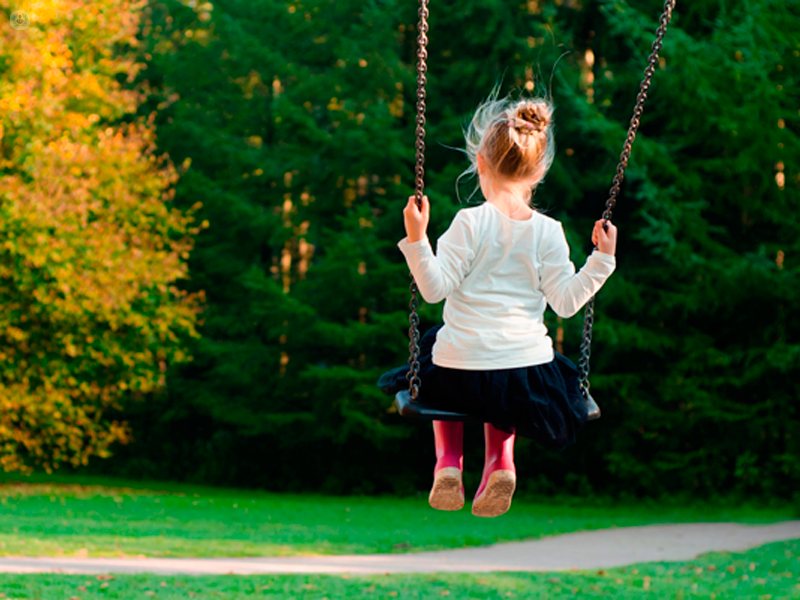 bambina sull'altalena in un parco