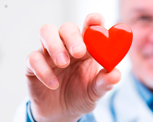 Medico che mostra un oggetto a forma di cuore