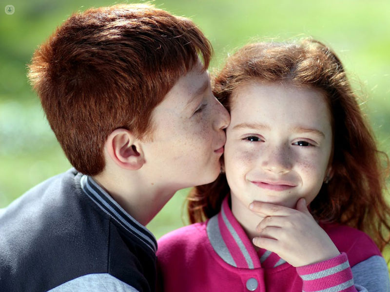 un ragazzino bacia sulla guancia una ragazzina