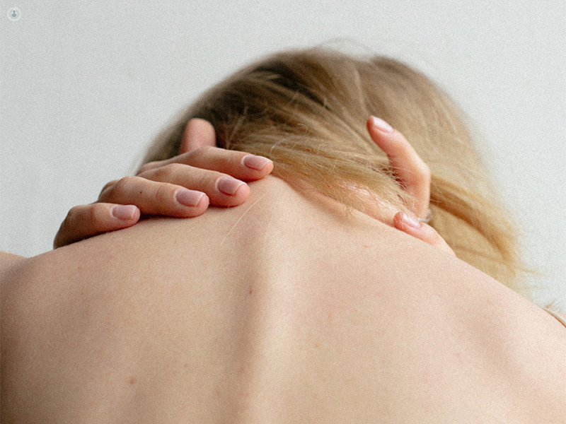 ragazza di spalle con dolore al collo