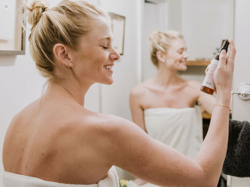 ragazza in bagno che si cura la pelle con un prodotto con urea