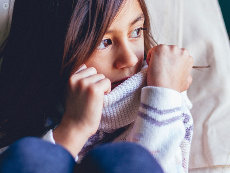 bambina con mal di pancia, seduta per terra