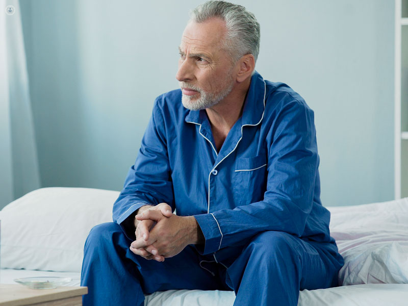 signore seduto sul letto preoccupato