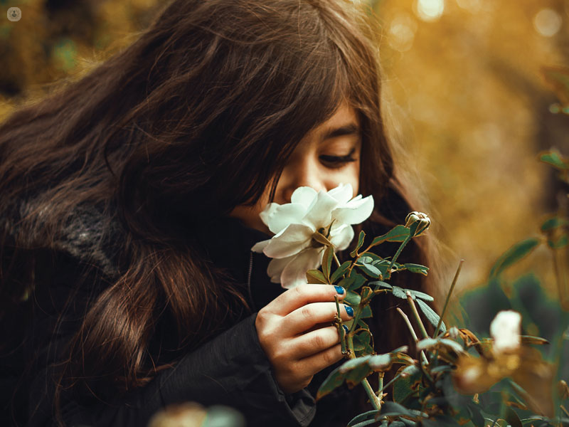 ragazzina che annusa un fiore