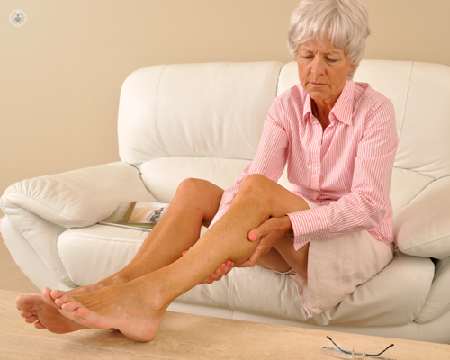 signora anziana con protesi anca che si tocca le gambe 